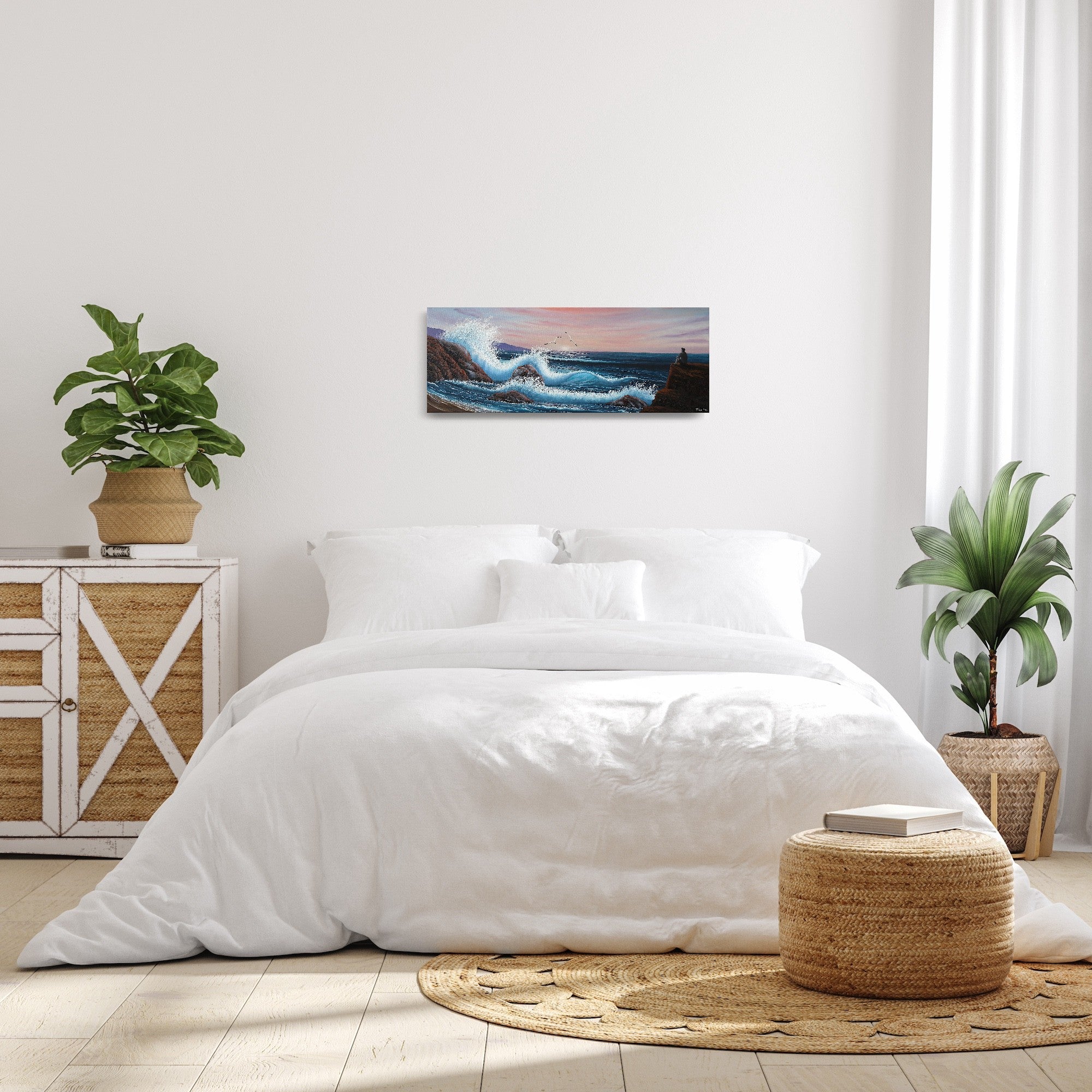 Oil painting on canvas showing a dramatic seascape with large blue waves crashing against rocky cliffs at sunset. Pink and purple clouds fill the sky. A grey person sits on a rock, gazing out at the ocean. The painting is shown in a bedroom.