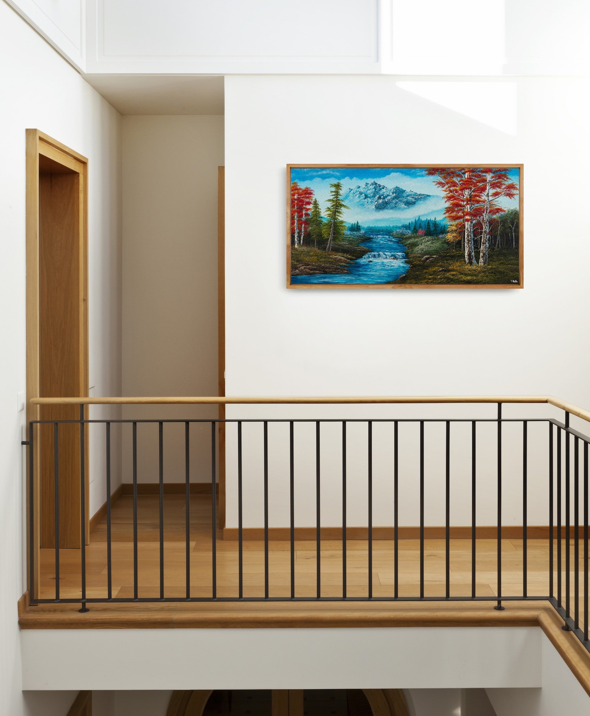 Premium canvas art print showing big mountains and an extensive forest landscape with red trees and a small river with a waterfall, printed on high-quality canvas with vibrant colors, displayed next to a wooden staircase.