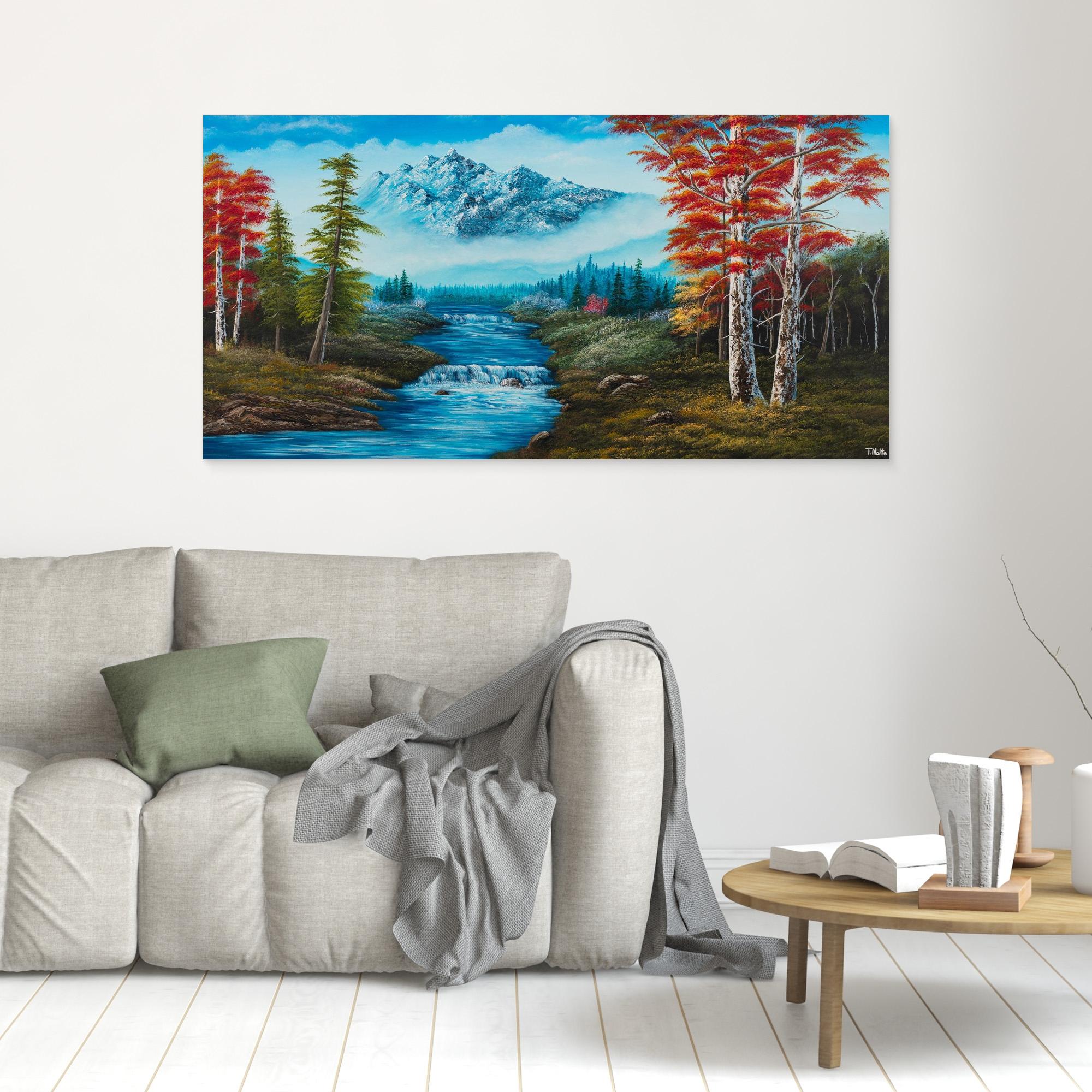 Premium canvas art print showing big mountains and an extensive forest landscape with red trees and a small river with a waterfall, printed on high-quality canvas with vibrant colors, displayed in a modern living room.